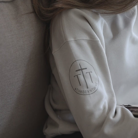 woman sitting on a couch reading a book while wearing a sweatshirt